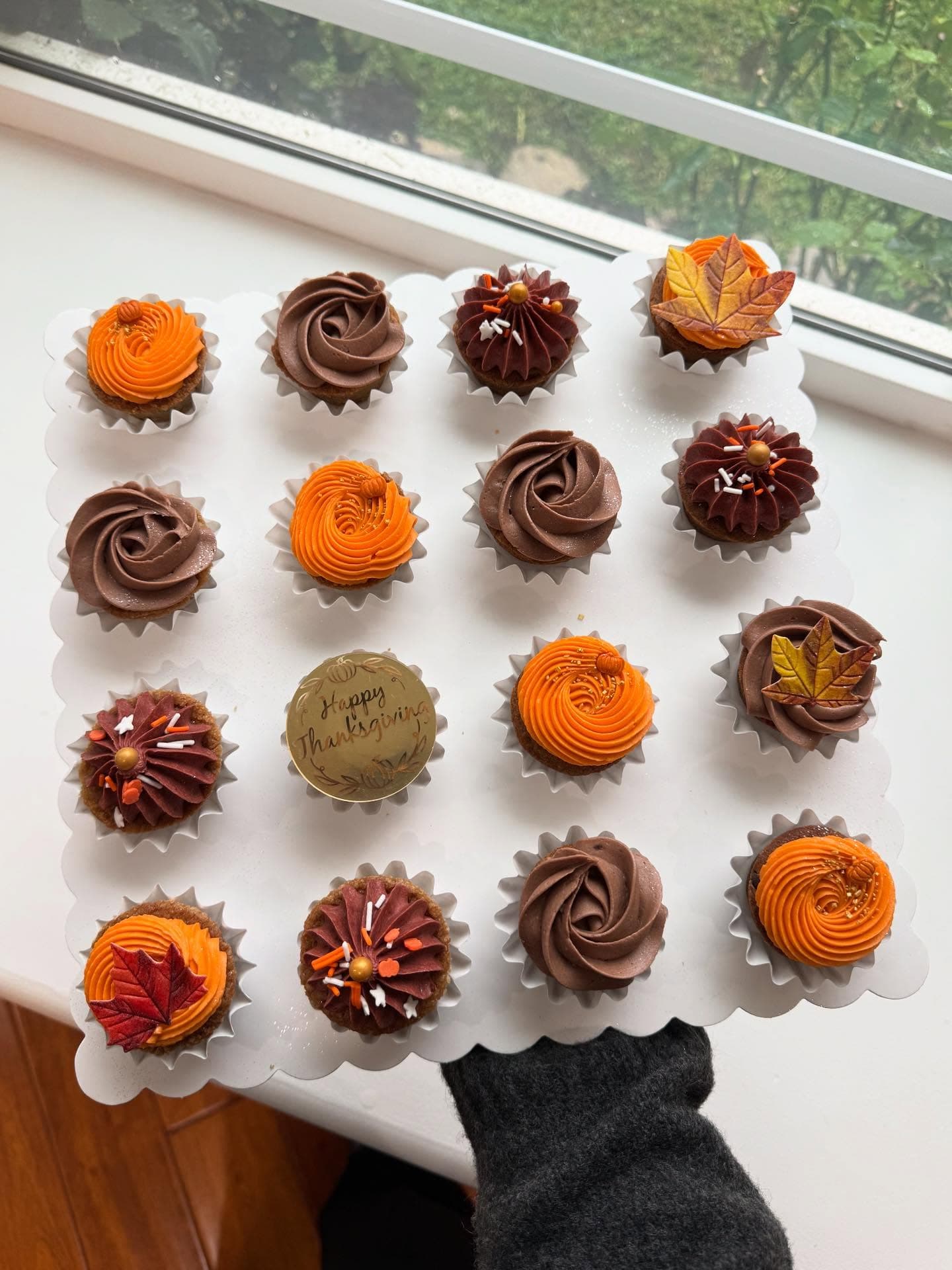 Thanksgiving cupcake board with chocolate and orange frosting, fall leaves and a Happy Thanksgiving cookie